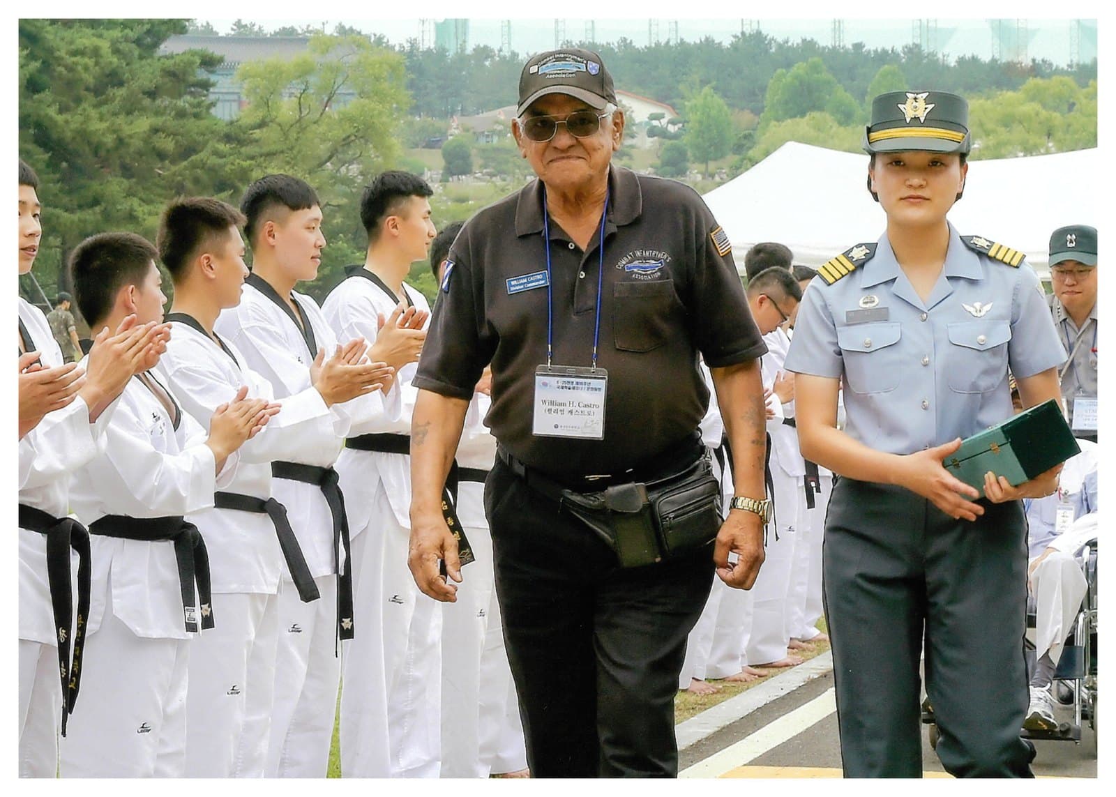 William Castro walking past a line of applauding young Koreans