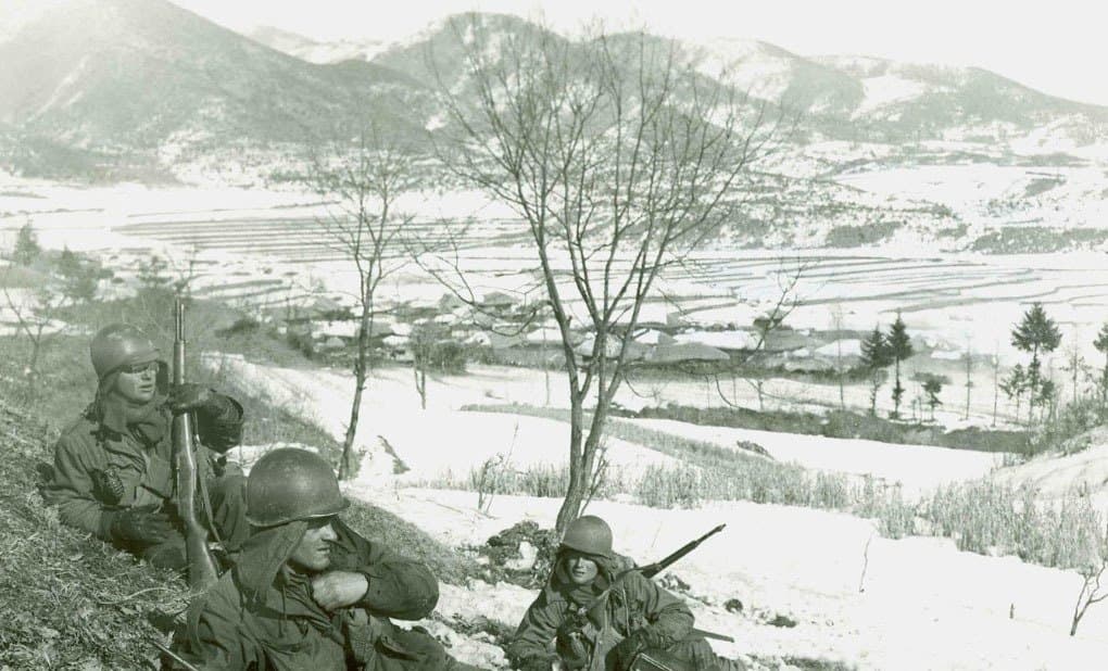 Soldiers gathered at night, one being decorated in the field