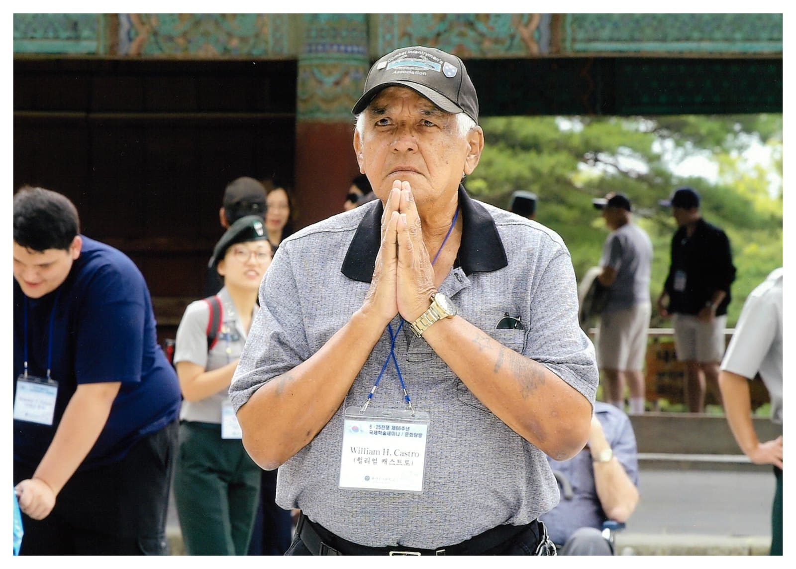 William Castro standing with hands pressed together during a memorial visit to Korea